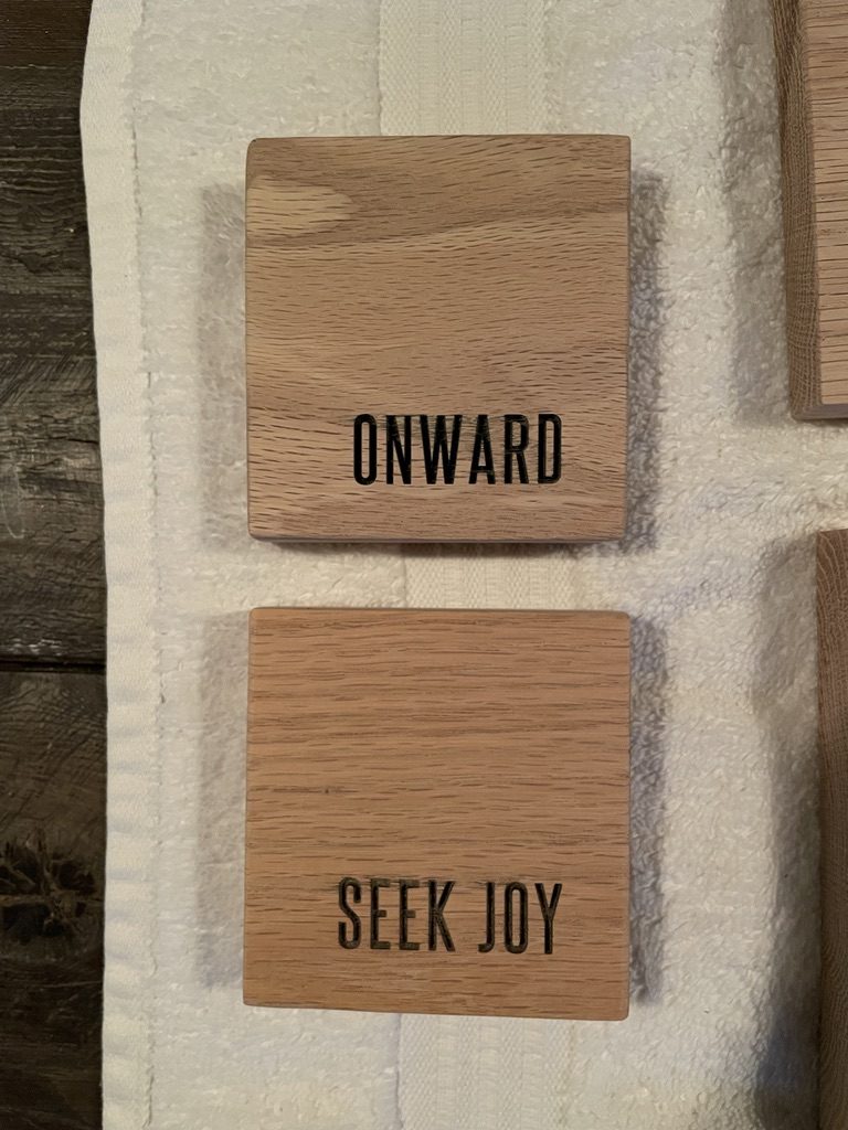 Oak coasters engraved ONWARD and SEEK JOY