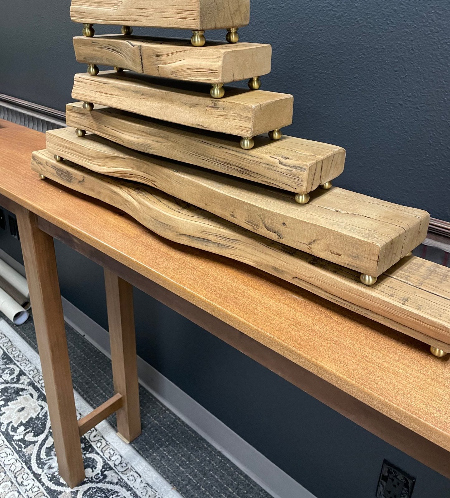 Stacked reclaimed-wood trays on brass ball feet